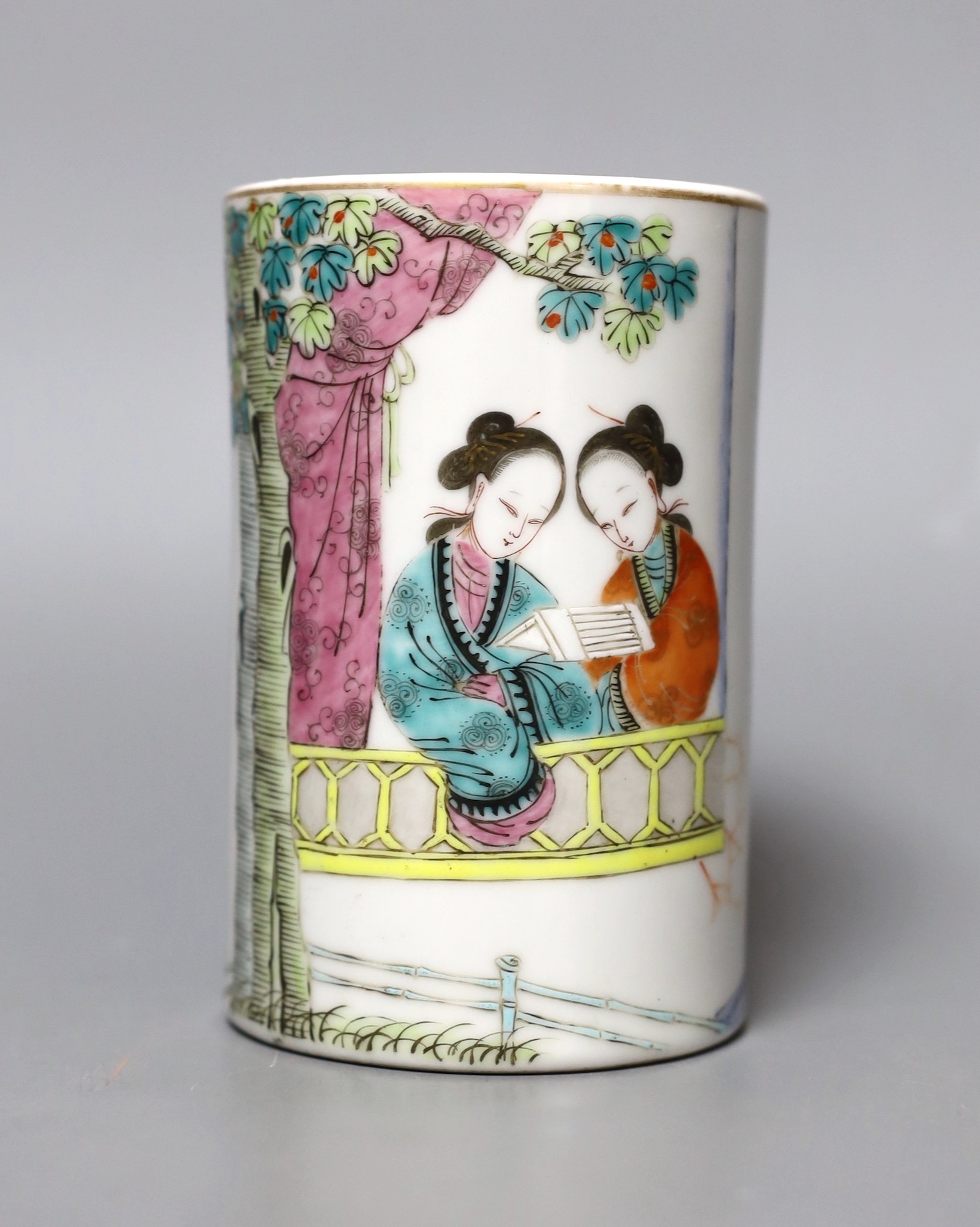 A Chinese famille rose brush pot with seated figures, 12cm tall